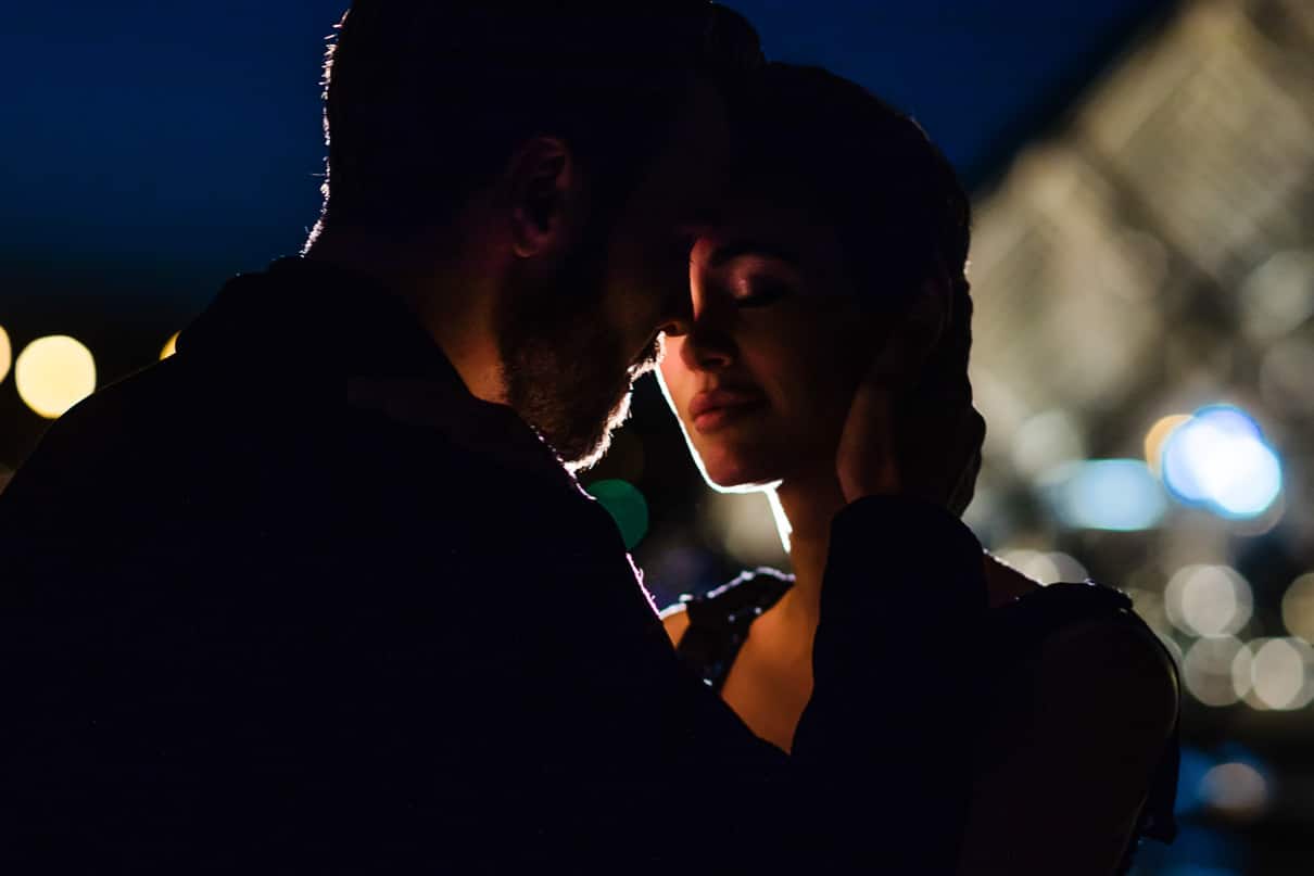 Romantic Paris engagement photos at the Louvre at night during the Blue Hour